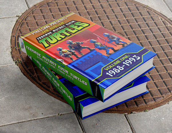 Stack of TMNT toy guide books on a sewer cover